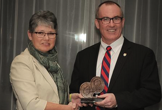 Janet shaking hands and receiving an award.