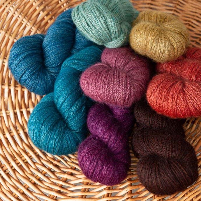 Basket of hand-dyed Lady Slipper fingering weight alpaca yarns from Green Gable Alpacas.